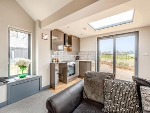 a living room with a couch and a kitchen at Mayton Lodge in Fordwich