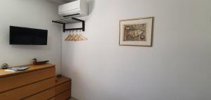 a room with a tv on a wall with a dresser at Apartment-Studio-Ginkgo-A1 in Banjole