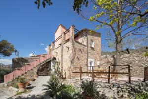 un vieux bâtiment en pierre avec une clôture à côté dans l'établissement Incantevole Veranda Panoramica, à Albenga