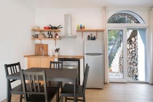 Il comprend une cuisine équipée d'une table et d'un réfrigérateur blanc. dans l'établissement Incantevole Veranda Panoramica, à Albenga