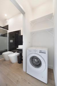 - un lave-linge blanc dans la salle de bains pourvue de toilettes dans l'établissement Incantevole Veranda Panoramica, à Albenga