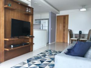 sala de estar con TV de pantalla plana y sofá en Apartamento Bora Bora Resort en Río de Janeiro