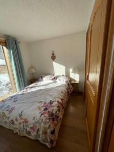 une chambre avec un lit avec un couvre-lit fleuri dans l'établissement Vue splendide Mont Blanc, à Saint-Gervais-les-Bains