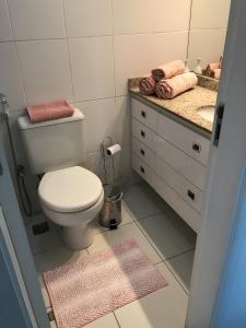 a bathroom with a white toilet and a sink at Apartamento Bora Bora Resort in Rio de Janeiro