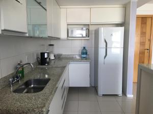 uma cozinha com um frigorífico branco e um lavatório em Apartamento Bora Bora Resort no Rio de Janeiro