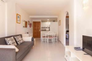 ein Wohnzimmer und eine Küche mit einem Sofa und einem Tisch in der Unterkunft Codonyer A in Port de Pollença