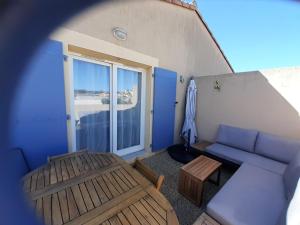 穆里耶的住宿－Sous le soleil des Alpilles，客厅配有蓝色的沙发和桌子