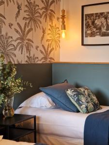een slaapkamer met een bed met blauwe en witte kussens bij Les Lauriers in Saint-Tropez