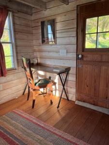 a wooden room with a wooden table and a chair at Historic 1850's Cosmic Cabin 