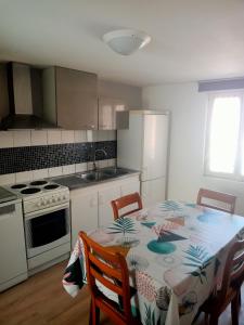 a kitchen with a table and chairs and a kitchen with a stove at appartement 2-3 pièce in Pfaffenhoffen