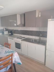 a kitchen with white cabinets and a sink and a table at appartement 2-3 pièce in Pfaffenhoffen