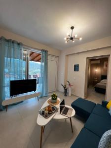 sala de estar con sofá azul y TV en Veni's Apartments, en Potos
