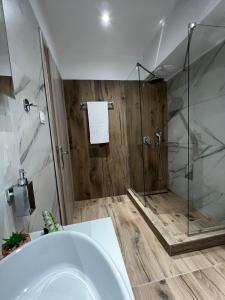 a bathroom with a shower and a white tub at Veni's Apartments in Potos +72 photos