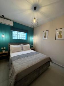 a bedroom with a bed and a blue wall at Veni's Apartments in Potos