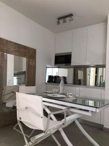 een keuken met een glazen tafel en een witte stoel bij Splendide studio, 10' a pied de Monaco + parking in Beausoleil
