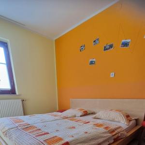 um quarto com uma cama com uma parede laranja em Apartma Tanja em Kamnik