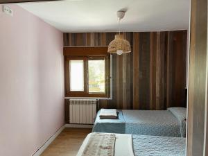 a bedroom with two beds and a window at Apartamentos Turísticos Casa Nieves in La Franca