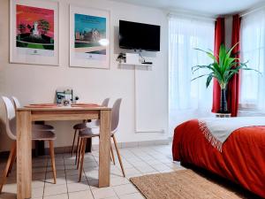 a bedroom with a table and a bed and a tv at COSY CASE proche Paris la Défense in Conflans-Sainte-Honorine