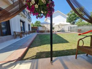 a patio with a table and chairs and an umbrella at Vila SIA Eforie Sud in Eforie Sud
