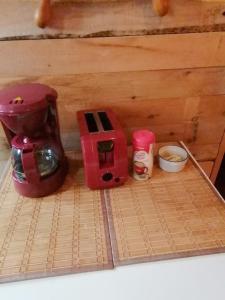 uma máquina de café vermelha sentada em cima de uma mesa em L'Oasis du Pirate em Quebeque