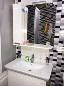 uma casa de banho com um lavatório branco e um espelho. em 2room apartment 100sq m With a Beautiful Mountain views em Almaty