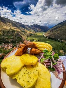 un plato de comida con maíz y verduras en una mesa en Altar Inca Hotel Mirador, en Cusco