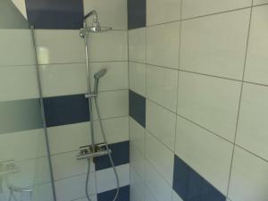 La salle de bains est pourvue d'une douche et de carrelage bleu et blanc. dans l'établissement Appartement Le Lavandou, 3 pièces, 4 personnes - FR-1-308-49, au Lavandou