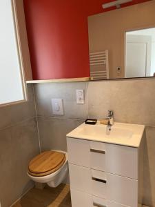 ein Badezimmer mit einem WC, einem Waschbecken und einem Spiegel in der Unterkunft Val-André vue sur mer in Pléneuf-Val-André