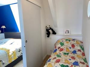 ein Schlafzimmer mit einem Bett und einem gefüllten Panda-Bär auf einem Regal in der Unterkunft Val-André vue sur mer in Pléneuf-Val-André