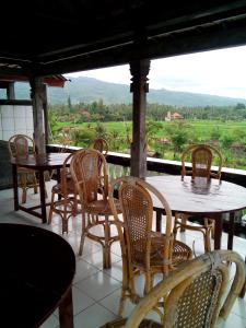 a group of tables and chairs sitting on a porch at Hotel Dupa in Lovina