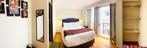 um quarto com uma cama e uma grande janela em Hotel Valle Andino em Cusco
