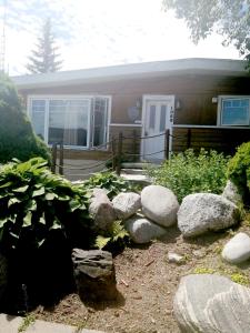 una casa con rocas delante de un patio en L'Oasis du Pirate en Quebec