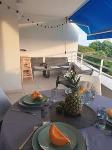 une table avec un ananas et des plaques de fruits dans l'établissement Chez Tonton David 972, à Fort-de-France