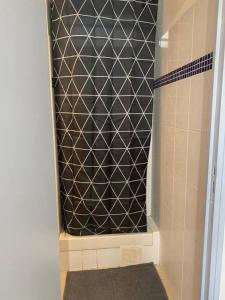 - une douche avec un mur carrelé noir et blanc dans l'établissement Chez Tonton David 972, à Fort-de-France