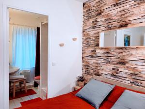 a bedroom with a brick accent wall and a bed at COSY CASE proche Paris la Défense in Conflans-Sainte-Honorine
