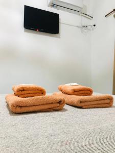 three towels sitting on the floor in front of a tv at Hotel Puerto Libertad - Iguazú in Puerto Libertad