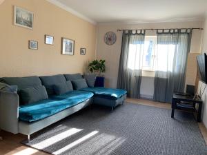 ein Wohnzimmer mit einem blauen Sofa und einem TV in der Unterkunft Ferienwohnung mit Garten in Köln in Köln