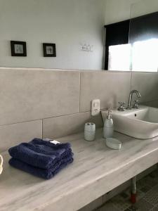 un baño con lavabo y una toalla azul en una encimera en El Refugio en Concepción del Uruguay