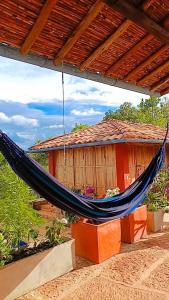 a hammock hanging in front of a house at Casa Upa ,casa con piscina espectacular, Barichara in Barichara