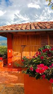 a house with red flowers in front of it at Casa Upa ,casa con piscina espectacular, Barichara in Barichara