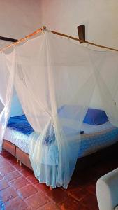 a bed with a mosquito net in a room at Casa Upa ,casa con piscina espectacular, Barichara in Barichara