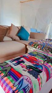 a living room with a couch and a colorful blanket at Casa Upa ,casa con piscina espectacular, Barichara in Barichara +62 photos