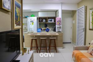 a kitchen with a counter and stools in a room at Qavi - Flat em Resort Beira Mar Cotovelo #InMare57 in Parnamirim