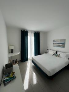 Un dormitorio con una gran cama blanca y una ventana en Domus Silvana Apartments, en Rávena