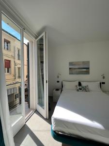 a white bedroom with a bed and a balcony at Domus Silvana Apartments in Ravenna