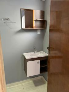 ein Bad mit einem Waschbecken und einem Spiegel in der Unterkunft Casa do Bruno in Olímpia