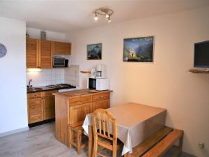 a small kitchen with a table and a microwave at Appartement 2 pièces cabine, 100m pistes, parking gratuit - FR-1-297-127 in Auris