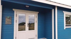 une maison bleue avec une porte blanche dans l'établissement Pure Space, à Kilkee