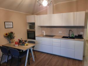 加爾尼亞諾的住宿－Il limone，厨房配有白色橱柜和桌椅