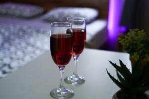 two glasses of wine sitting on a table at Apartment Wonderland in Niš